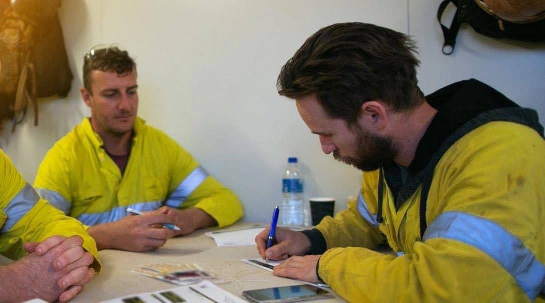 two men writing safety and compliance examples