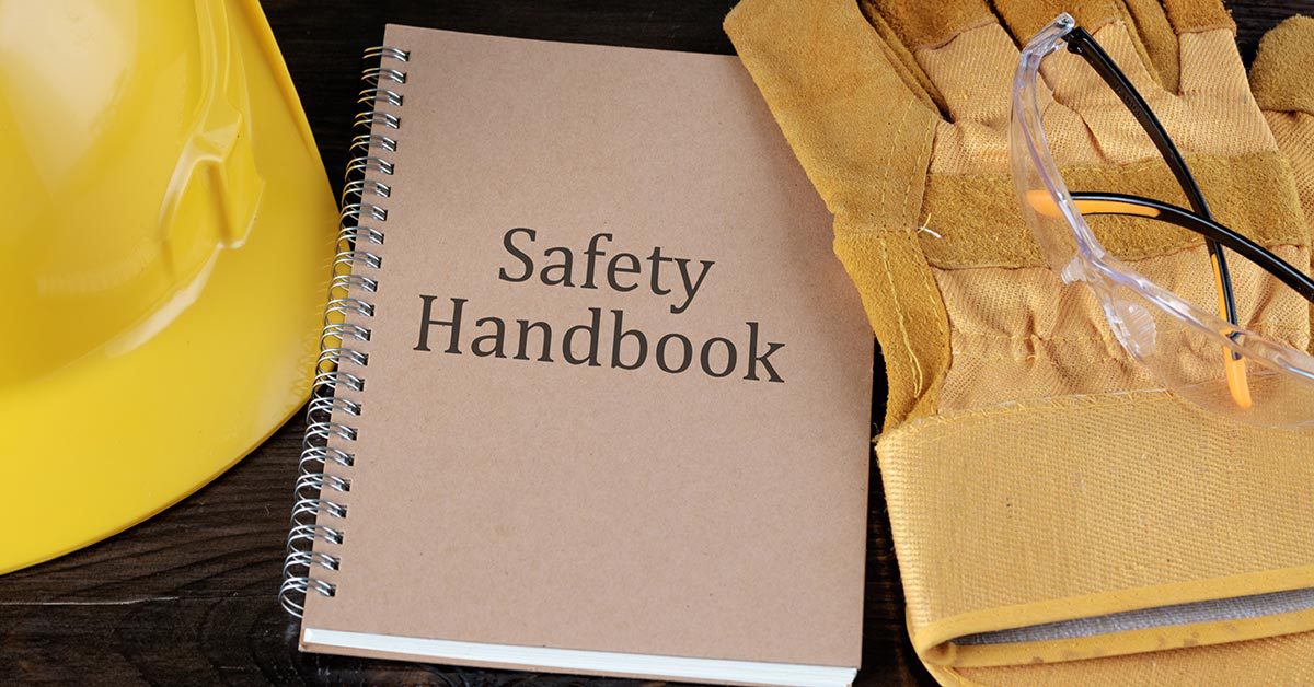 A brown construction safety training handbook next to construction gear