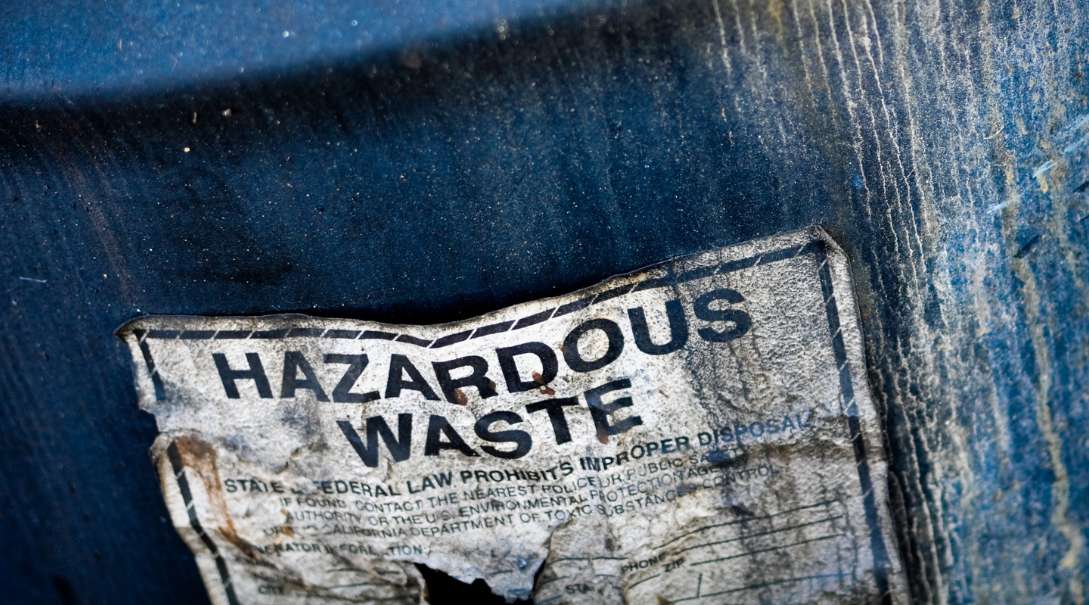 A barrel that says hazardous waste on it