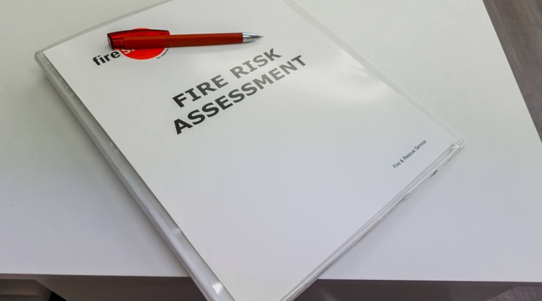 A binder that says “Fire Risk Assessor” on it