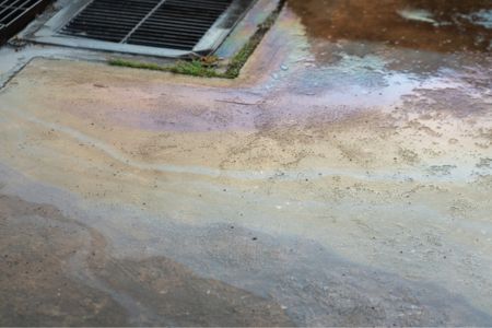A diesel spill on concrete running into the gutter