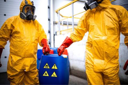Two people in Hazmat suits complying with the TSCA