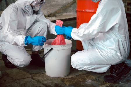 Two emergency response workers disposing of hazardous waste in a distribution center