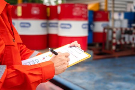 Worker taking inventory of waste in storage facility.
