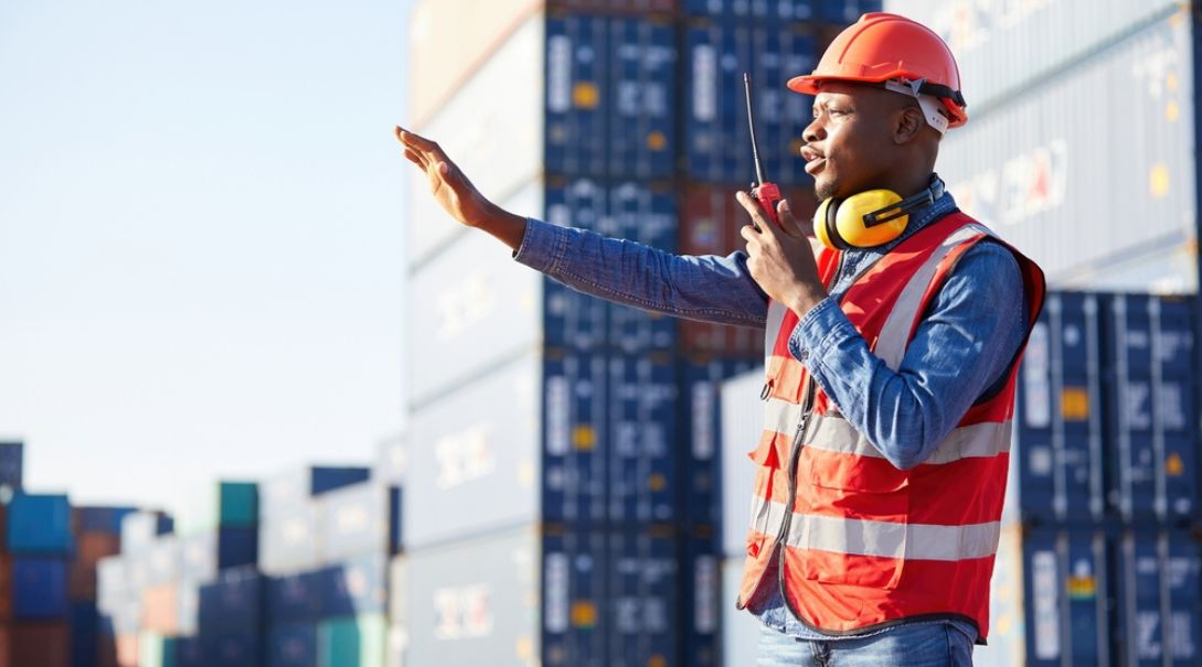 A worker wearing safety equipment signaling another worker