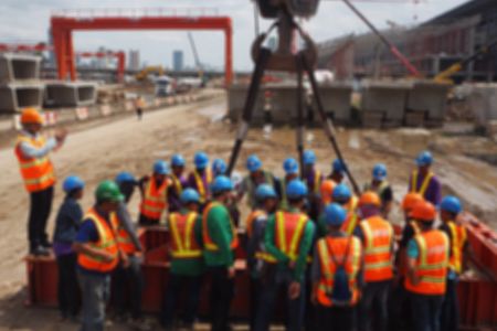 Workers on construction site getting crane training for certification.