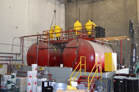 Workers cleaning out hazardous material tanks