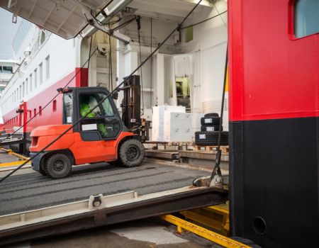 a forklift being driven up a ship ramp