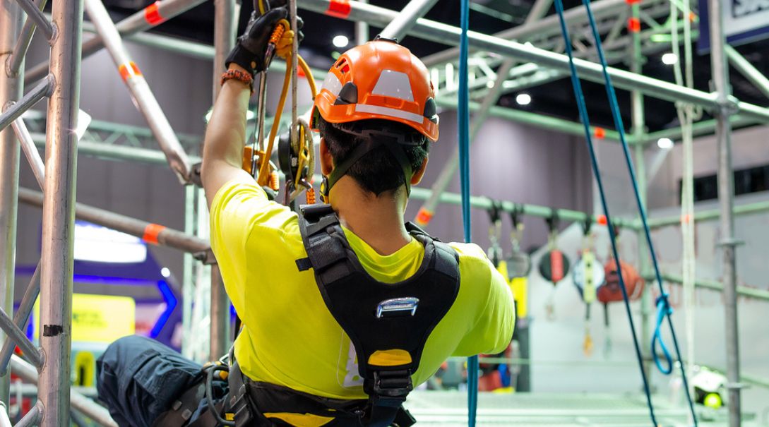 a man wearing a helmet and harness participating in scaffolding training