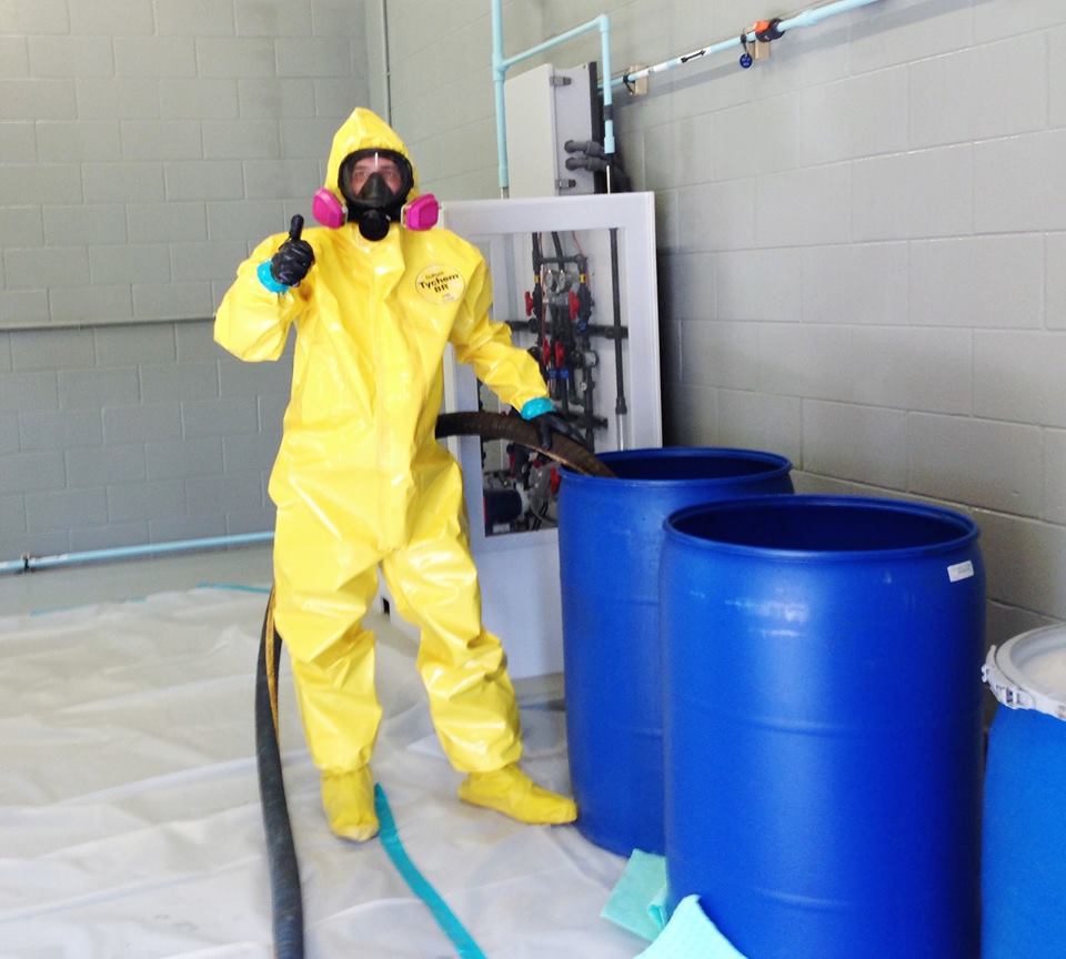 Person in protective suit with barrels.
