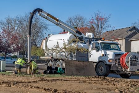 workers using a hydro excavation truck for digging