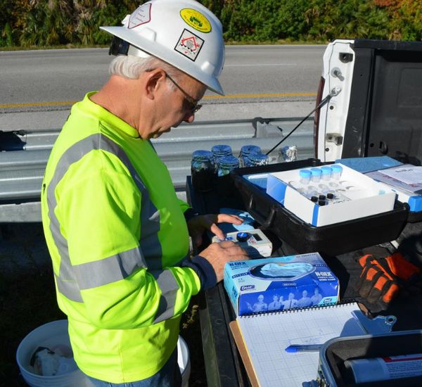 AOTC employee testing soil and water in back of work truck