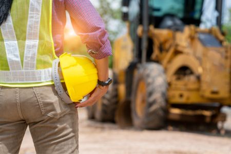 construction worker with a hard hat near heavy equipment