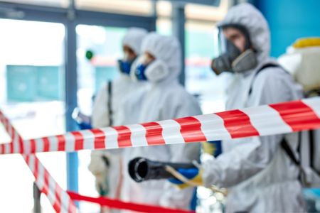 hazmat team behind safety tape