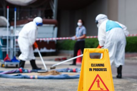 protected cleanup crew performing hazardous waste removal operations in a restricted area